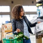 Woman taking box off the shelf in grocery store - suburbs or city