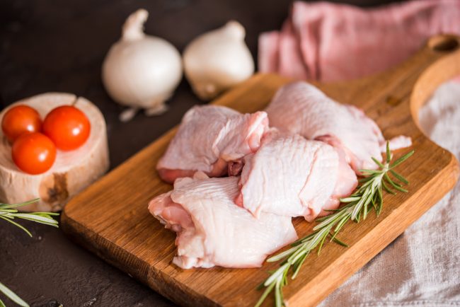 Chicken for grilled, spices, herbs, tomatoes, mushrooms on dark background, top view. Raw meat chicken for cooking. Delicious balanced food concept never wash your chicken