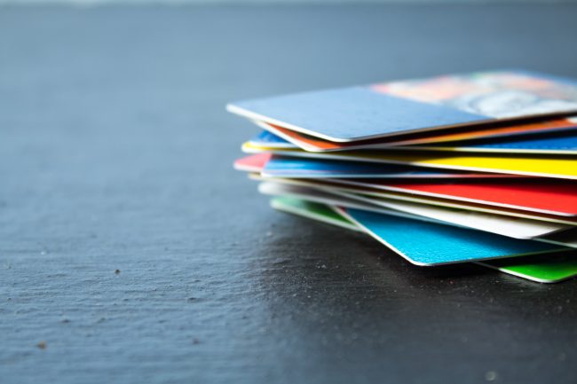 Stack of bank cards on a black background. gift cards with hidden fees
