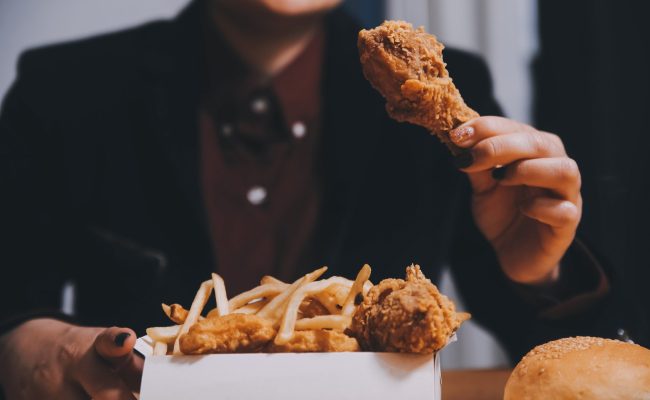 close up focus woman hand hold fried chicken for eat,girl with f discontinued product