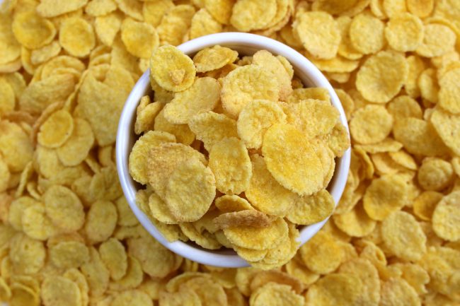 In a white plate are cornflakes for breakfast family-sized packs