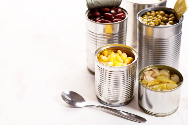 Various canned vegetables on kitchen table background. canned goods