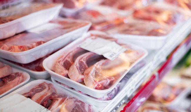 Packaged mutton meat laid out on display shelves of butcher store expiration dates