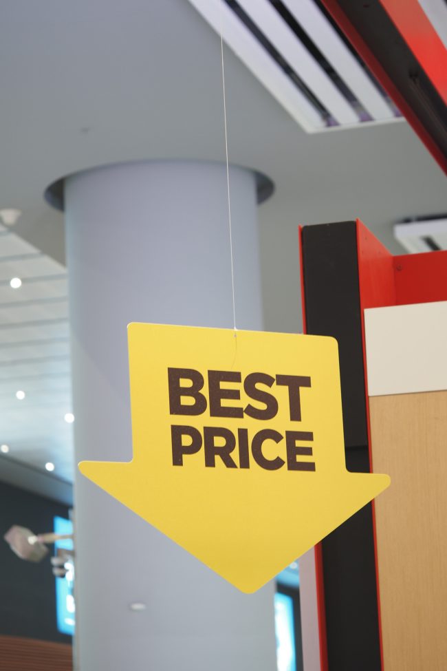 Sign indicating best price in a shopping mall during daylight raised prices