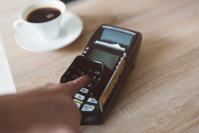 Consument entering pin code on card terminal loyalty program tracking