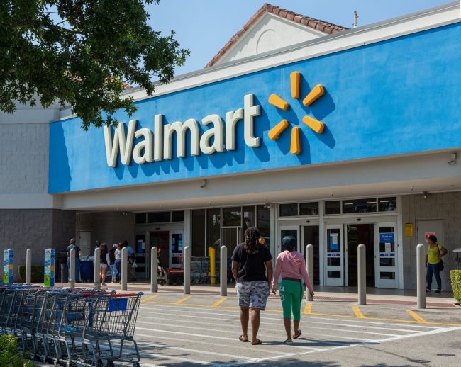 People near Walmart store. Walmart is the world’s third largest public corporation that runs chains of department stores. Coronavirus time. Shrinking Their Shopping Hours