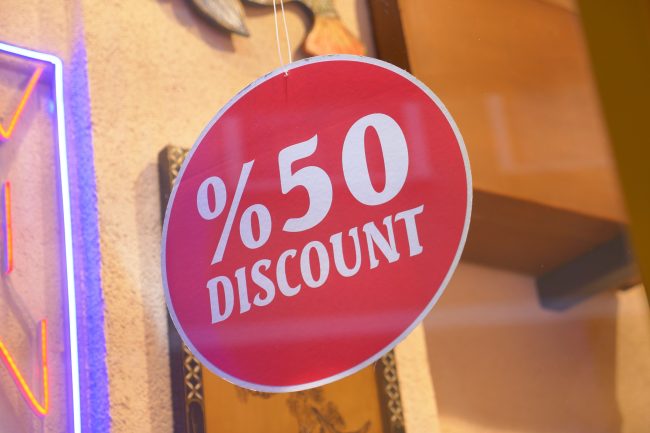 Store offers significant price reduction with 50 percent discount sign groceries before expiration