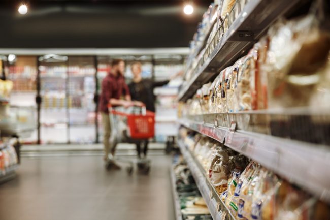 Concentrated young loving couple in supermarket being recorded
