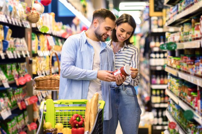 Happy,Couple,Buying,Food,In,Supermarket,,Choosing,Products,Standing,With grocery price hike