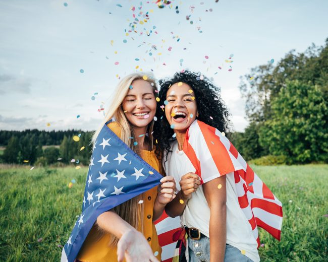 Two,Happy,Women,Covered,By,The,Usa,Flag.,Young,Friends Why These 9 Foods Are Always in Short Supply for July 4th