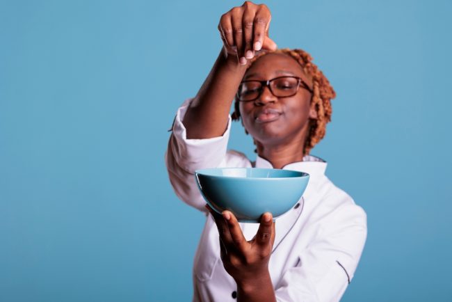 African,American,Chef,Holding,Bowl,Of,Food,While,Adding,Salt different kinds of salt