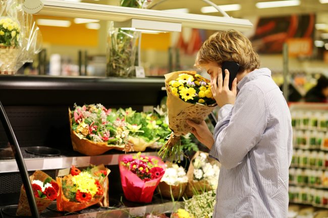 Man,Buying,Flowers,At,A,Garden,Center,.using,Smarthone Are the Grocery Store Flowers Really a Good Deal?