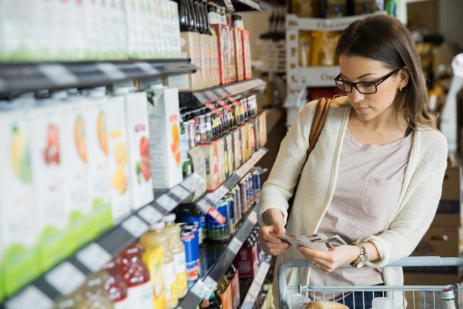 Woman,Shopping,With,Coupons,In,Market grocery coupon hacks