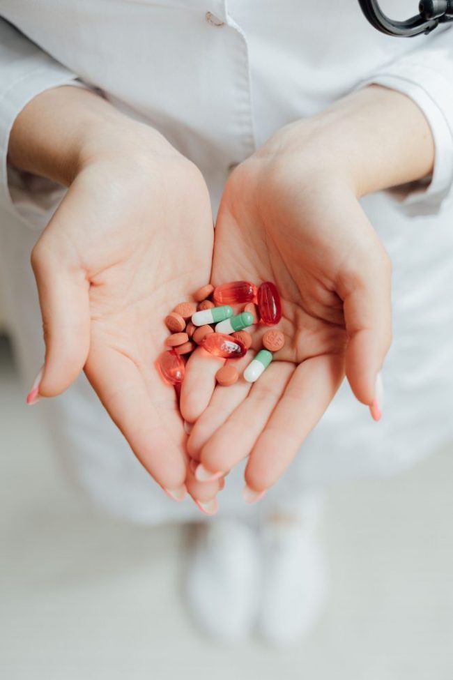 A medical professional holding a handful of various pills and capsules. Why Generic Medicine and Spices Are the Easiest Money Savers
