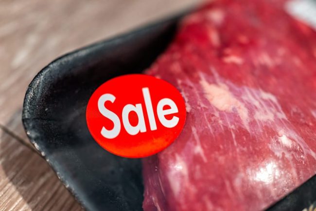 A package of raw meat featuring a red “Sale” sticker. Grocery Clearance Deals That Are Often Better Than Weekly Sales