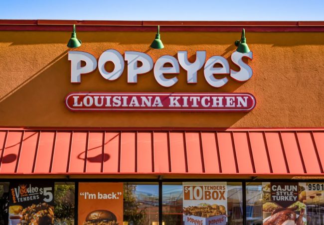 The exterior facade and sign of a Popeyes Louisiana Kitchen restaurant. Popeyes Has a $20 Family Meal — How Much Food Does That Actually Get You?