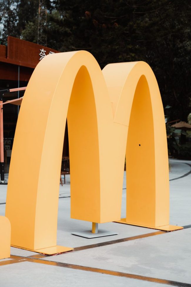 A large yellow golden arches McDonald’s logo structure outdoors. What Does $20 Buy at McDonald’s vs. Taco Bell?
