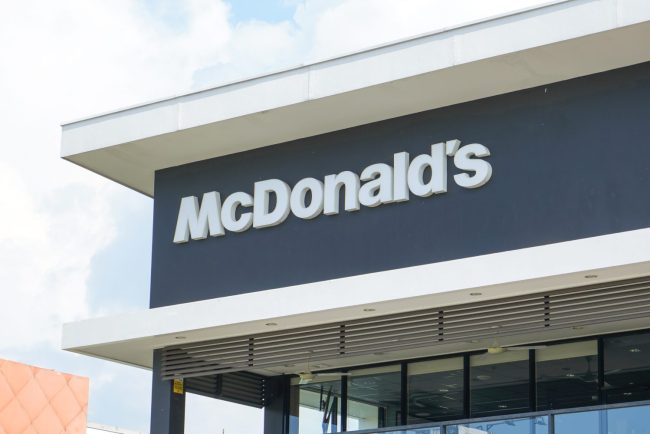 The exterior signage of a modern McDonald’s restaurant featuring the iconic white lettering. McDonald's Is Being Sued Over Its AI Pricing Tool — Could It Affect What You Pay?